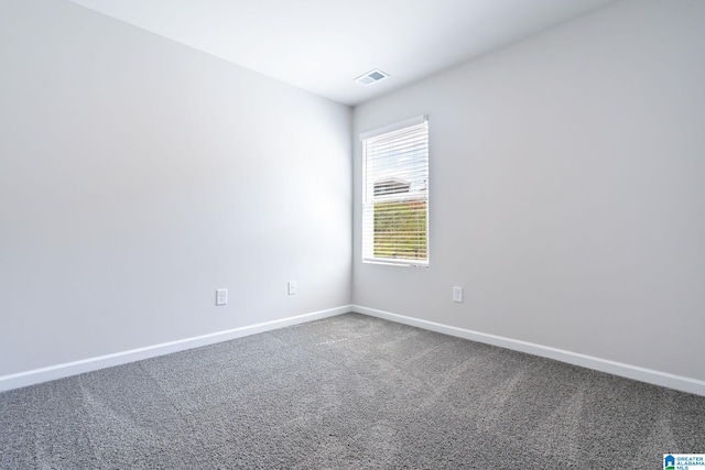 spare room with carpet flooring, visible vents, and baseboards