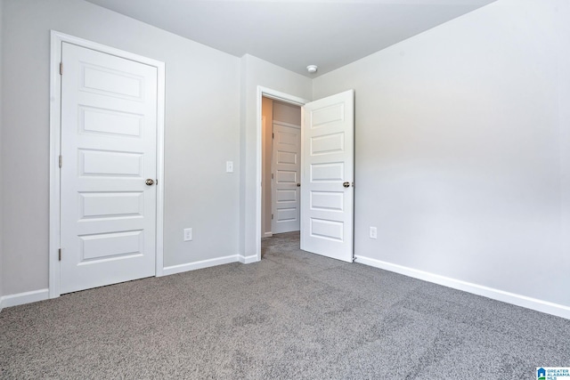 unfurnished bedroom featuring carpet and baseboards