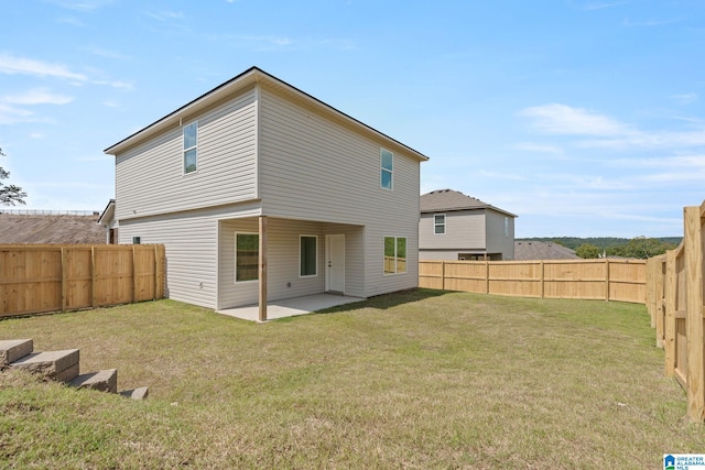 rear view of house featuring a yard, a patio area, and a fenced backyard