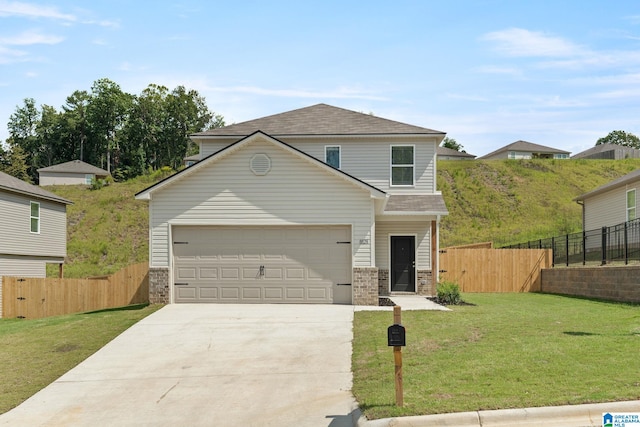 traditional-style house featuring a garage, fence, concrete driveway, and a front yard