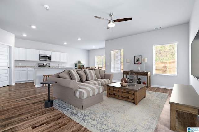 living room featuring dark wood-style floors, recessed lighting, visible vents, a ceiling fan, and baseboards