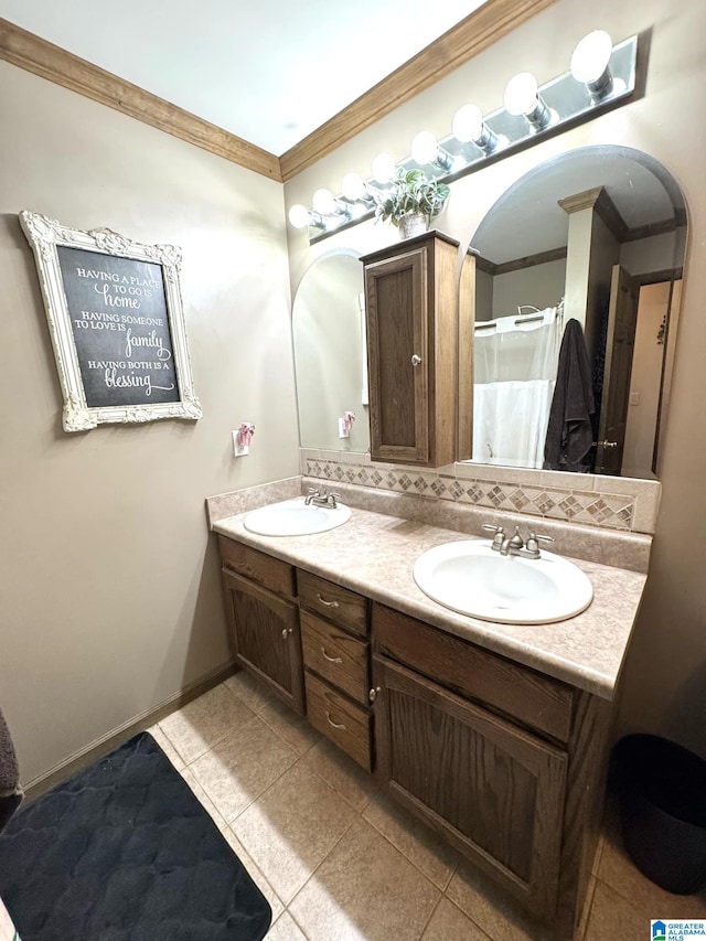 bathroom featuring baseboards, double vanity, a sink, and crown molding