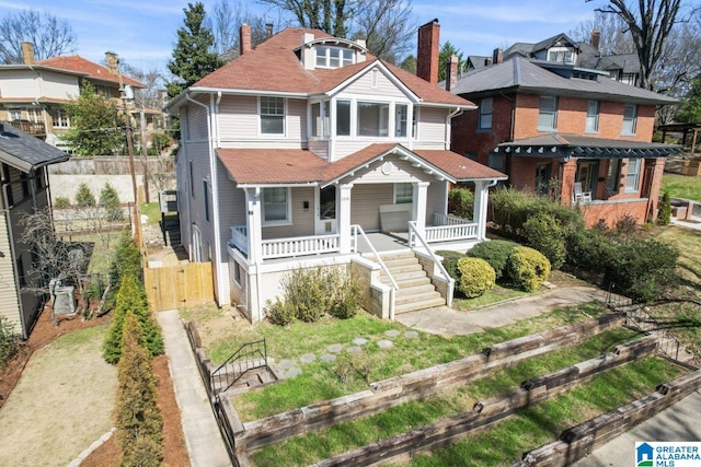 view of front of house featuring covered porch, a residential view, fence, and roof with shingles