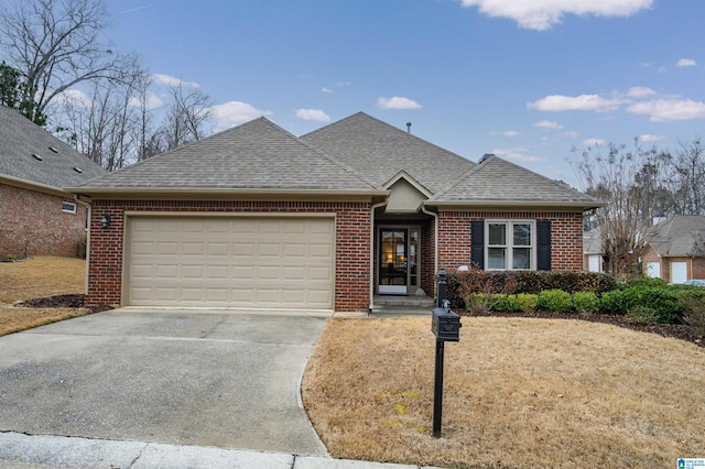 view of front of home with a garage, brick siding, driveway, and roof with shingles