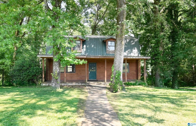 view of front facade featuring covered porch, metal roof, log exterior, and a front lawn