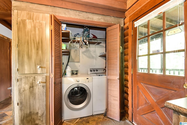 laundry room with laundry area, stone finish flooring, and washing machine and clothes dryer