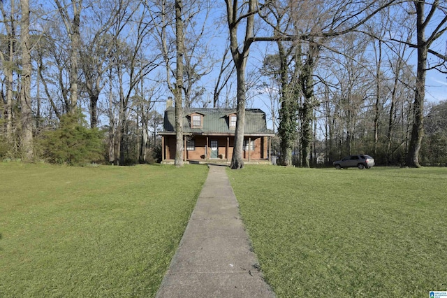 view of front of property featuring metal roof, a chimney, and a front yard