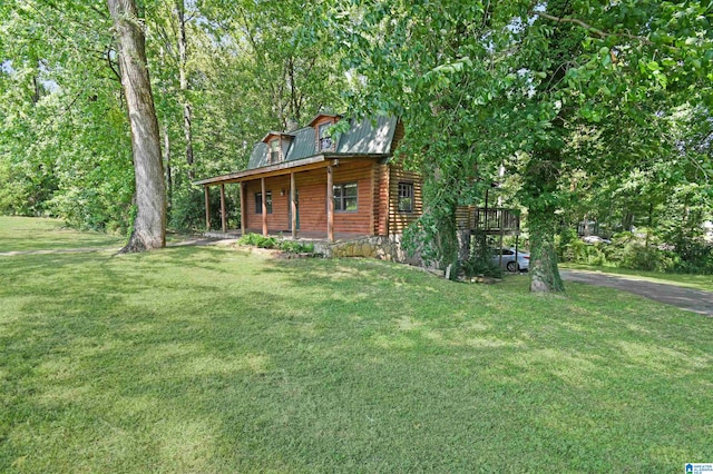 exterior space with a porch, metal roof, log exterior, and a front lawn