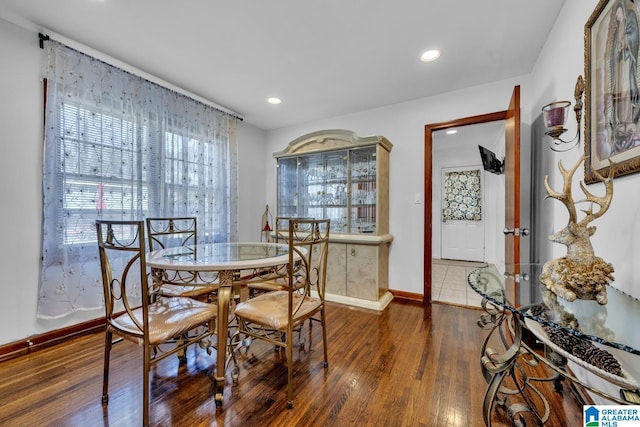 dining space featuring baseboards, dark wood finished floors, and recessed lighting