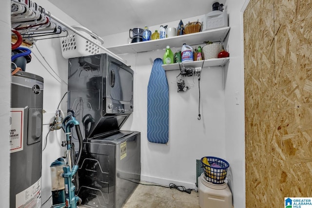 laundry room with laundry area, water heater, and stacked washer and dryer