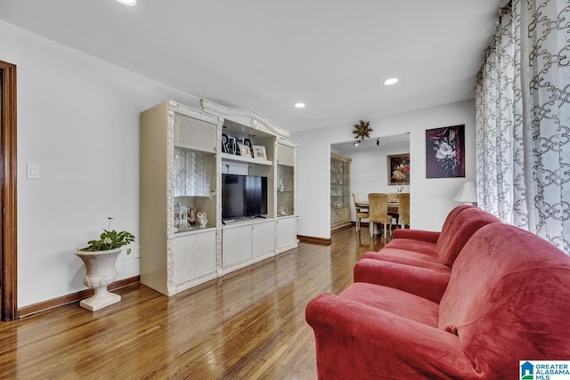 living area featuring baseboards, wood finished floors, and recessed lighting