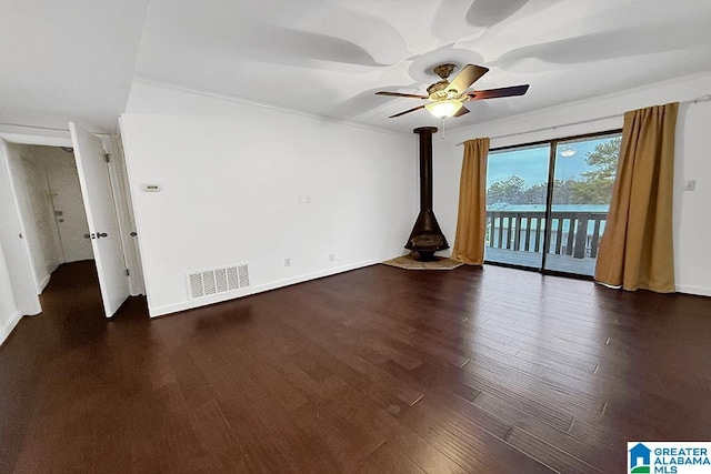 unfurnished living room featuring visible vents, baseboards, a ceiling fan, dark wood-style floors, and crown molding