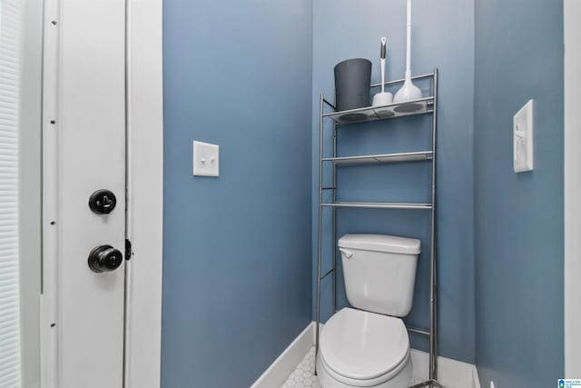 half bathroom with toilet and baseboards