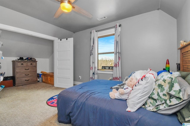 carpeted bedroom featuring lofted ceiling, ceiling fan, and visible vents