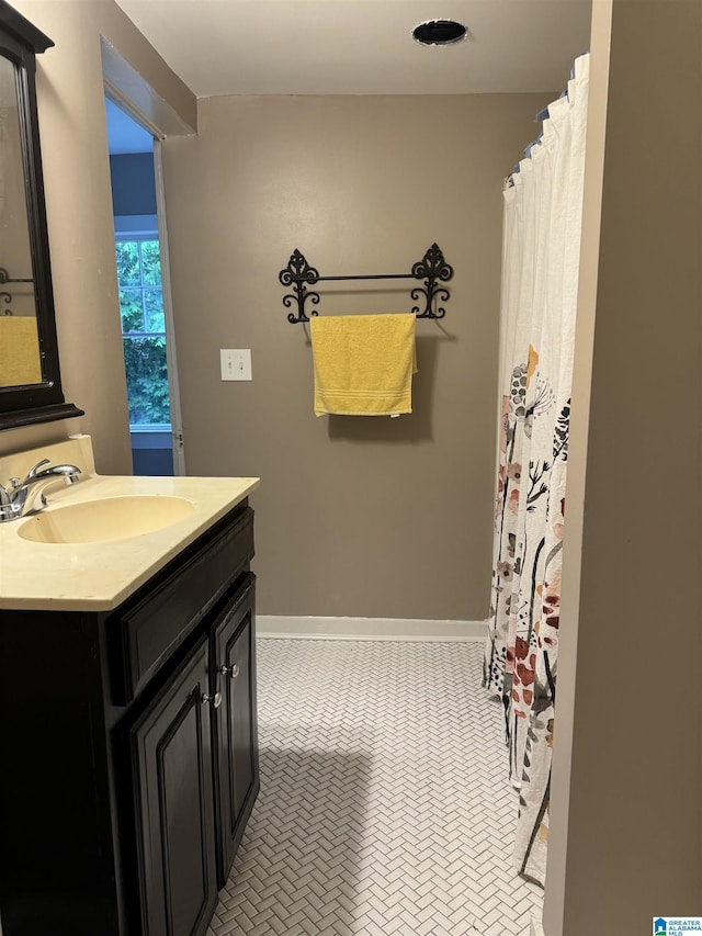 full bathroom with vanity and baseboards