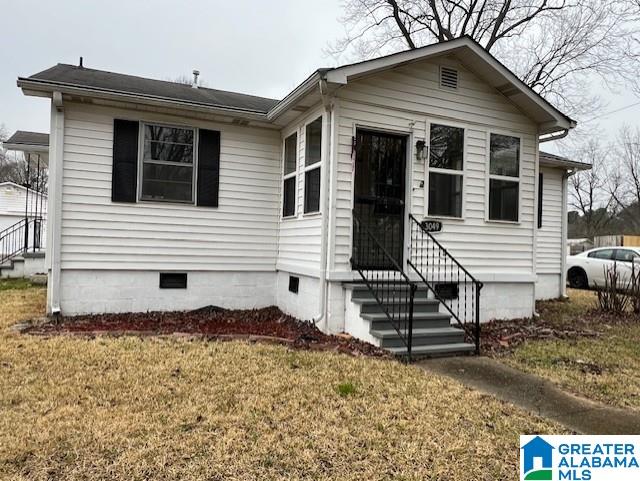 view of front of property featuring entry steps, crawl space, and a front yard