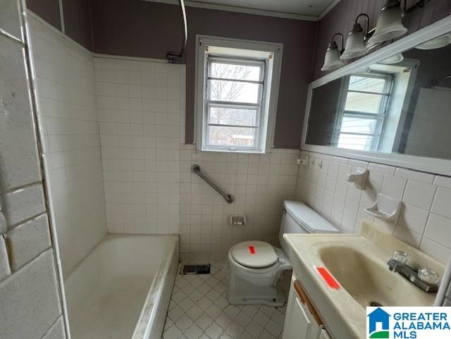 bathroom with tile walls, vanity, and toilet