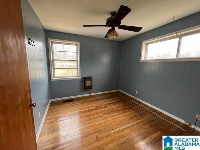 spare room with light wood-style flooring, visible vents, baseboards, and ceiling fan