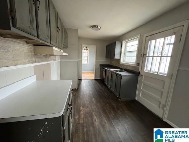 kitchen with dark wood-type flooring, gray cabinets, light countertops, and plenty of natural light