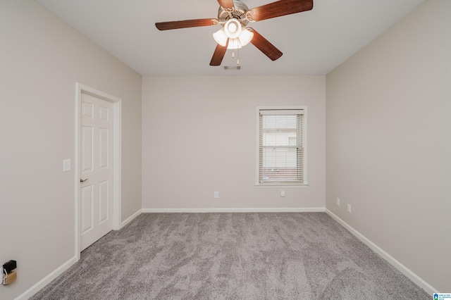 empty room featuring carpet floors, baseboards, visible vents, and ceiling fan