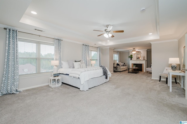 carpeted bedroom with ornamental molding, a fireplace, a raised ceiling, and baseboards