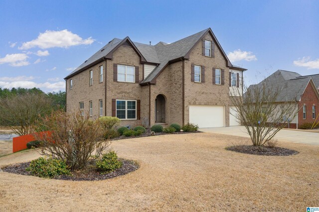 traditional-style house featuring driveway, brick siding, and an attached garage