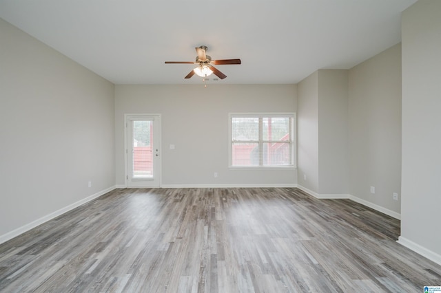 spare room with ceiling fan, wood finished floors, and baseboards