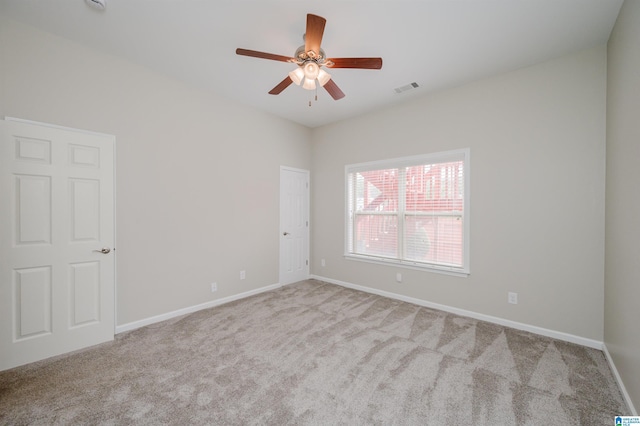 spare room featuring a ceiling fan, carpet, visible vents, and baseboards