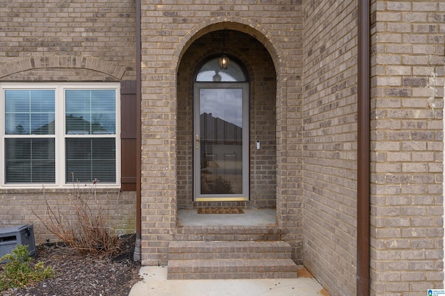 doorway to property with brick siding