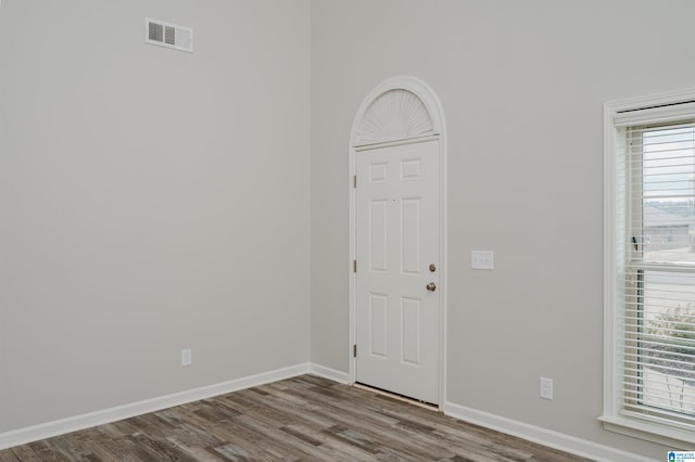 foyer entrance with visible vents, baseboards, and wood finished floors