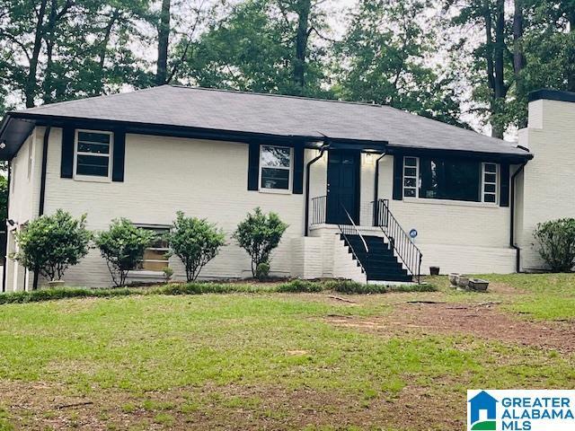 view of front of home featuring brick siding and a front yard