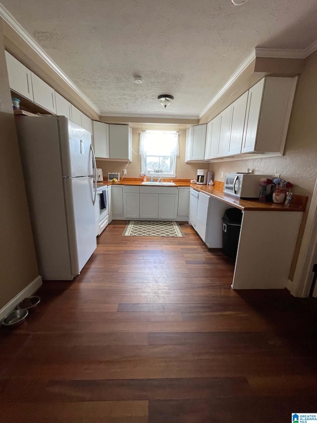 kitchen with ornamental molding, white appliances, dark wood-style flooring, and white cabinetry