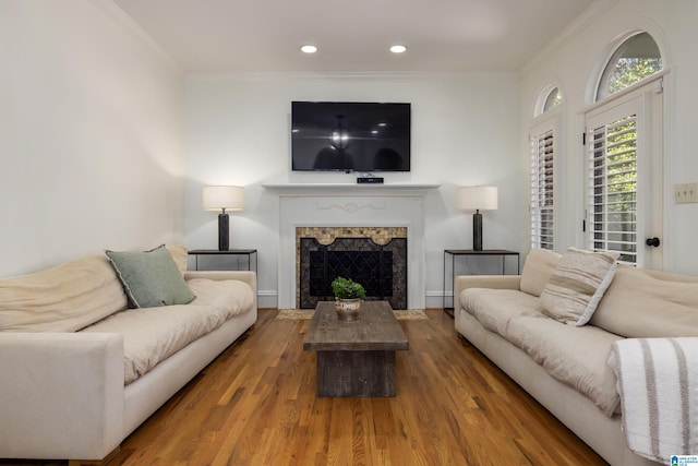 living area featuring ornamental molding, recessed lighting, a fireplace with flush hearth, and wood finished floors