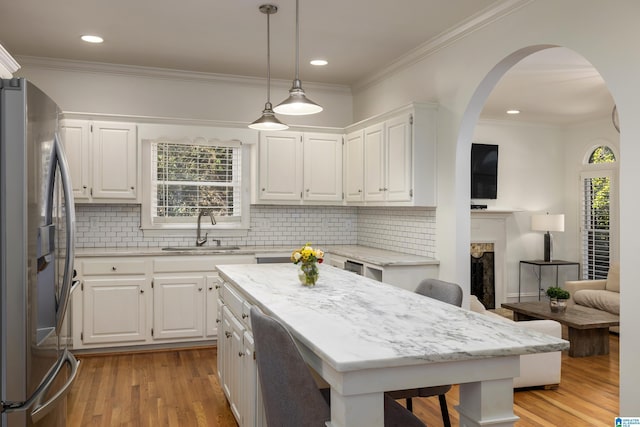 kitchen featuring pendant lighting, a center island, white cabinetry, and stainless steel fridge with ice dispenser