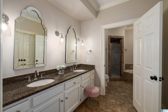 bathroom featuring ornamental molding, a stall shower, a sink, and toilet