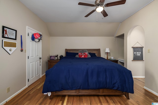 bedroom with lofted ceiling, baseboards, and wood finished floors