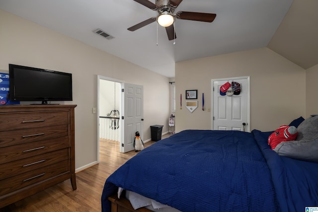 bedroom featuring lofted ceiling, ceiling fan, light wood-style flooring, visible vents, and baseboards