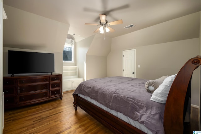 bedroom featuring ceiling fan, visible vents, vaulted ceiling, and wood finished floors