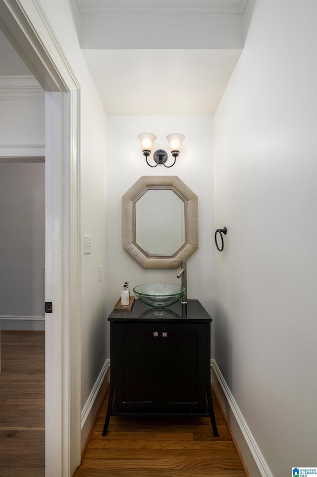 bathroom with baseboards, wood finished floors, and vanity