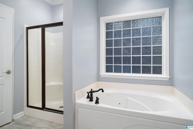 bathroom featuring a tub with jets and a stall shower