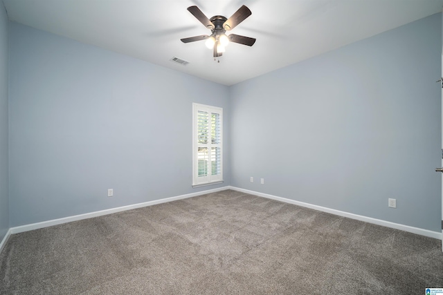 carpeted spare room featuring visible vents, ceiling fan, and baseboards