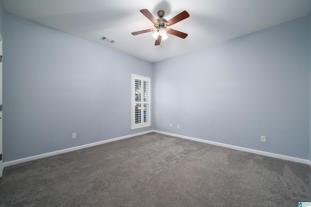 unfurnished room featuring a ceiling fan, visible vents, dark carpet, and baseboards