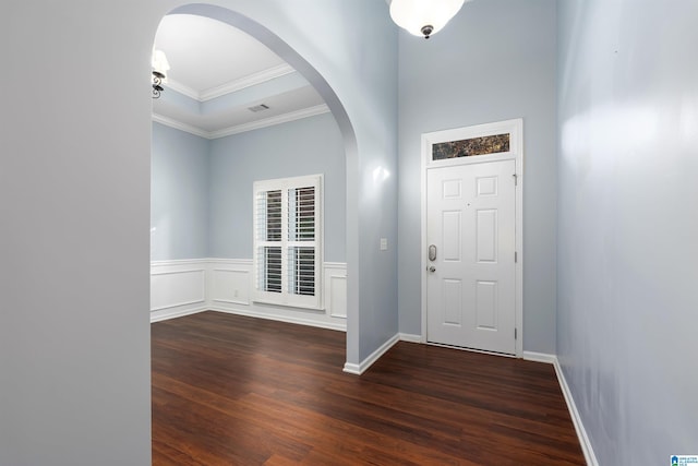 entryway with arched walkways, a decorative wall, a wainscoted wall, ornamental molding, and dark wood finished floors