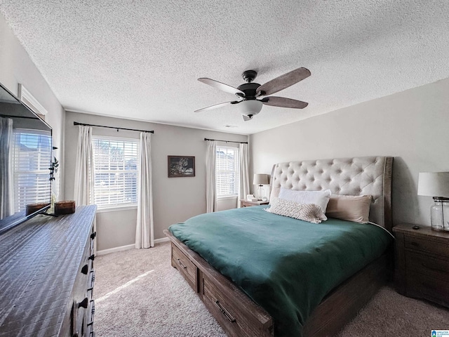 carpeted bedroom with multiple windows, ceiling fan, a textured ceiling, and baseboards