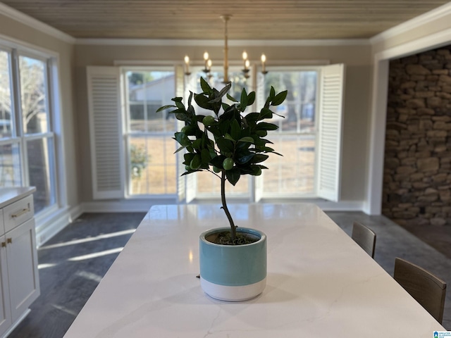 interior details with a chandelier, crown molding, and baseboards