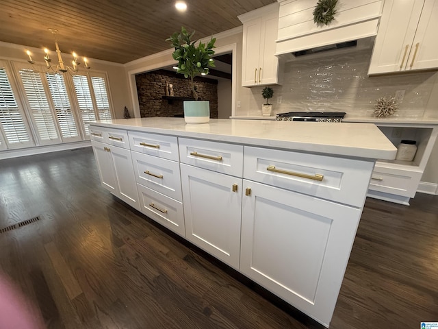 kitchen with hanging light fixtures, white cabinetry, light countertops, and dark wood-style flooring