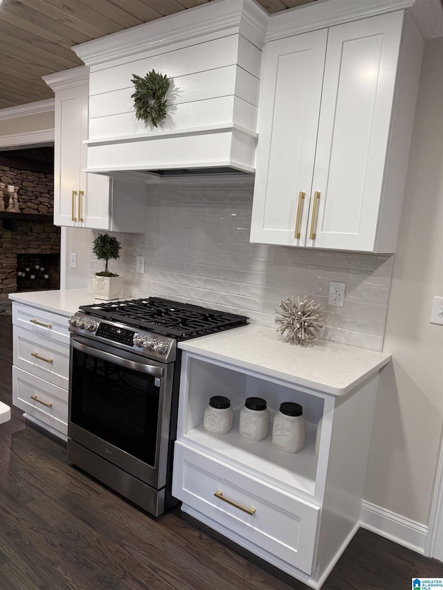 kitchen with stainless steel gas range, light countertops, white cabinetry, open shelves, and backsplash