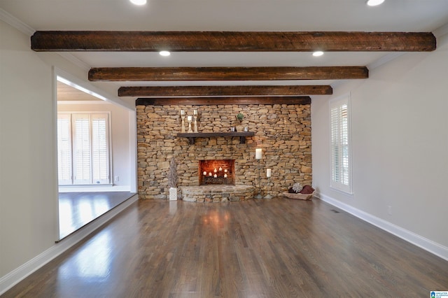 unfurnished living room featuring a healthy amount of sunlight, baseboards, and a stone fireplace