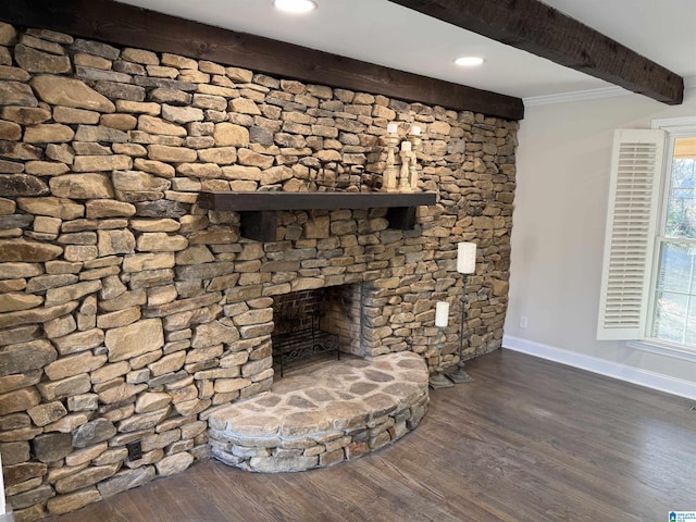 unfurnished living room with plenty of natural light, baseboards, a fireplace with raised hearth, dark wood finished floors, and beam ceiling