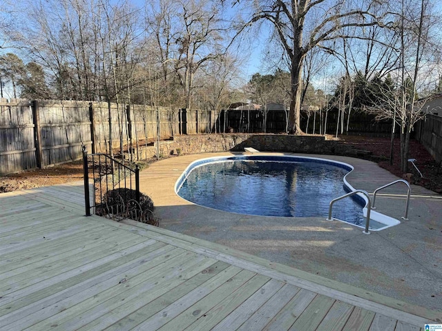 view of swimming pool featuring a fenced in pool, a fenced backyard, and a deck